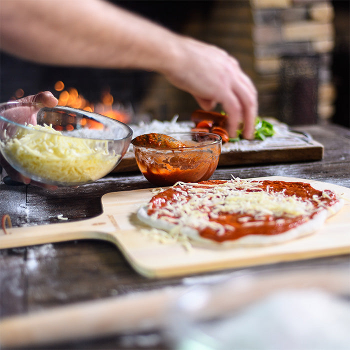 Pizza cooking on a Kamado Joe ceramic pizza stone