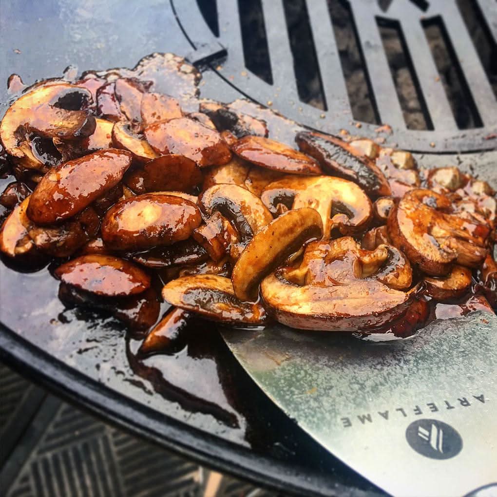 Mushrooms cooking on a grill -smokeforges