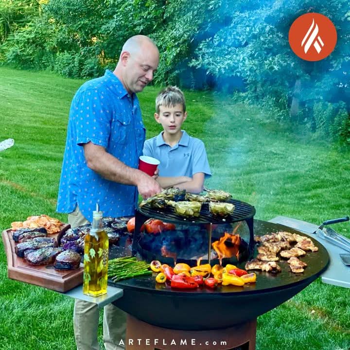 Arteflame Stainless Steel Side Warming Tables in use during a real outdoor cookout