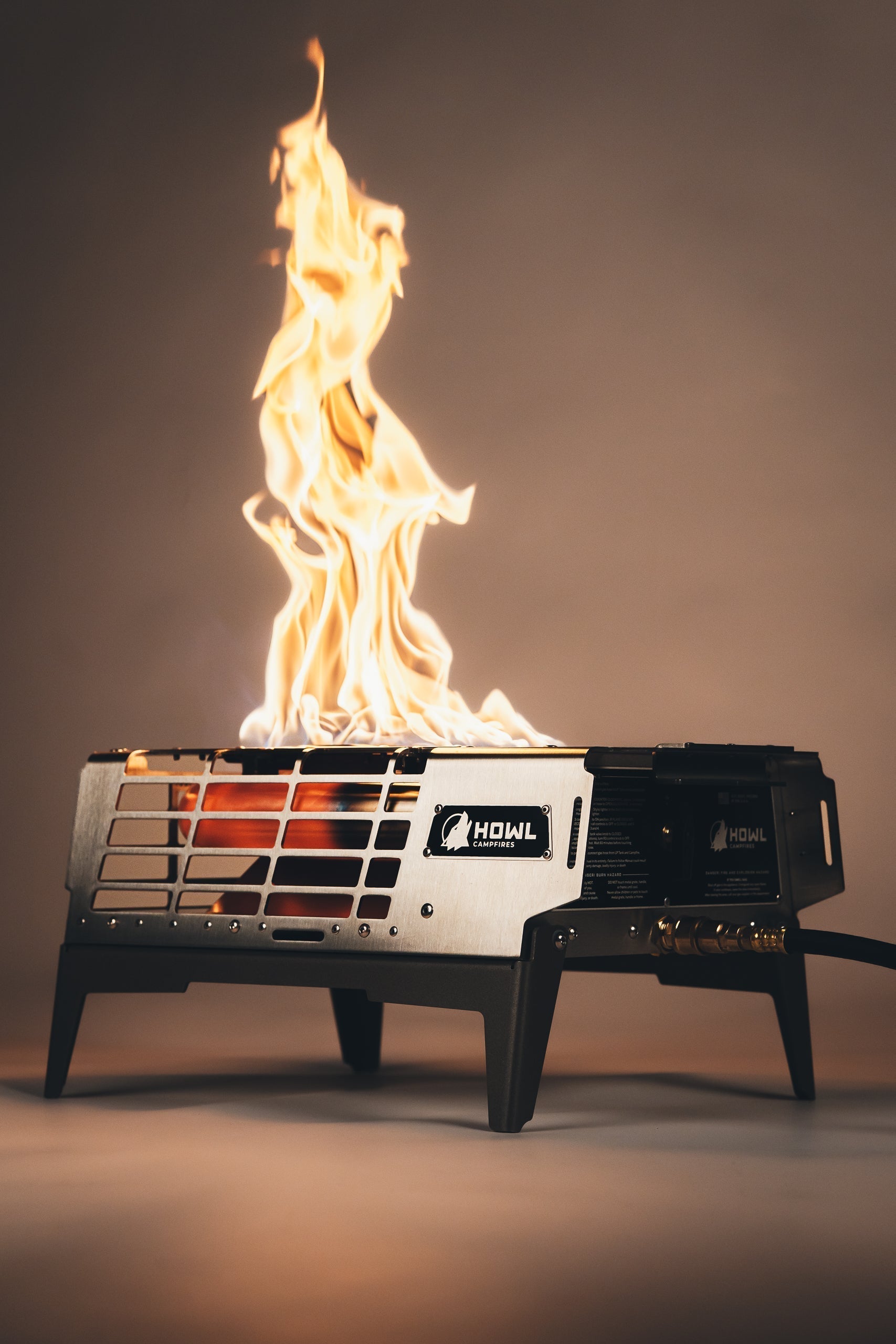 Howl R3 portable radiant propane fire pit burning at a campsite