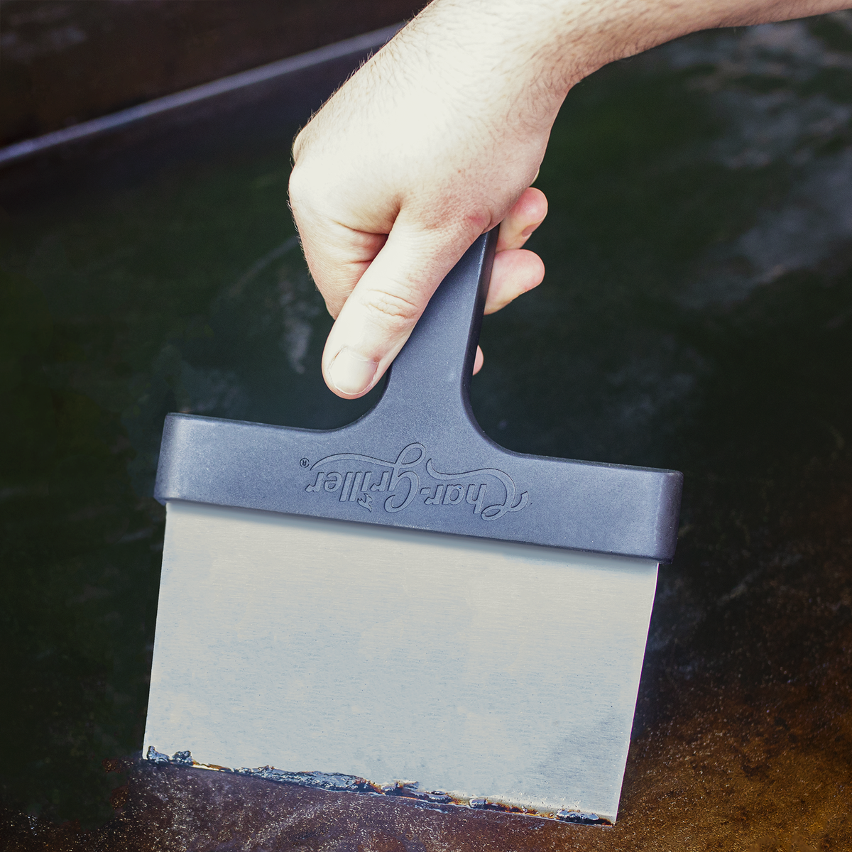 Char-Griller 8977 scraper cleaning a Flat Iron griddle