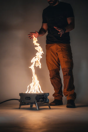 Man warming hands by Howl R1 propane fire pit - Smokeforges