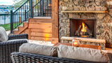 Majestic Courtyard 42 outdoor gas fireplace in a stone hearth on a lakeside patio