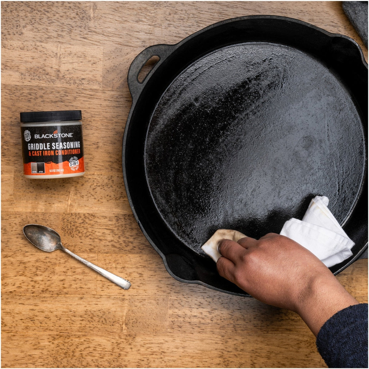 Blackstone Griddle Seasoning and Cast Iron Conditioner — wiping conditioner over cast iron