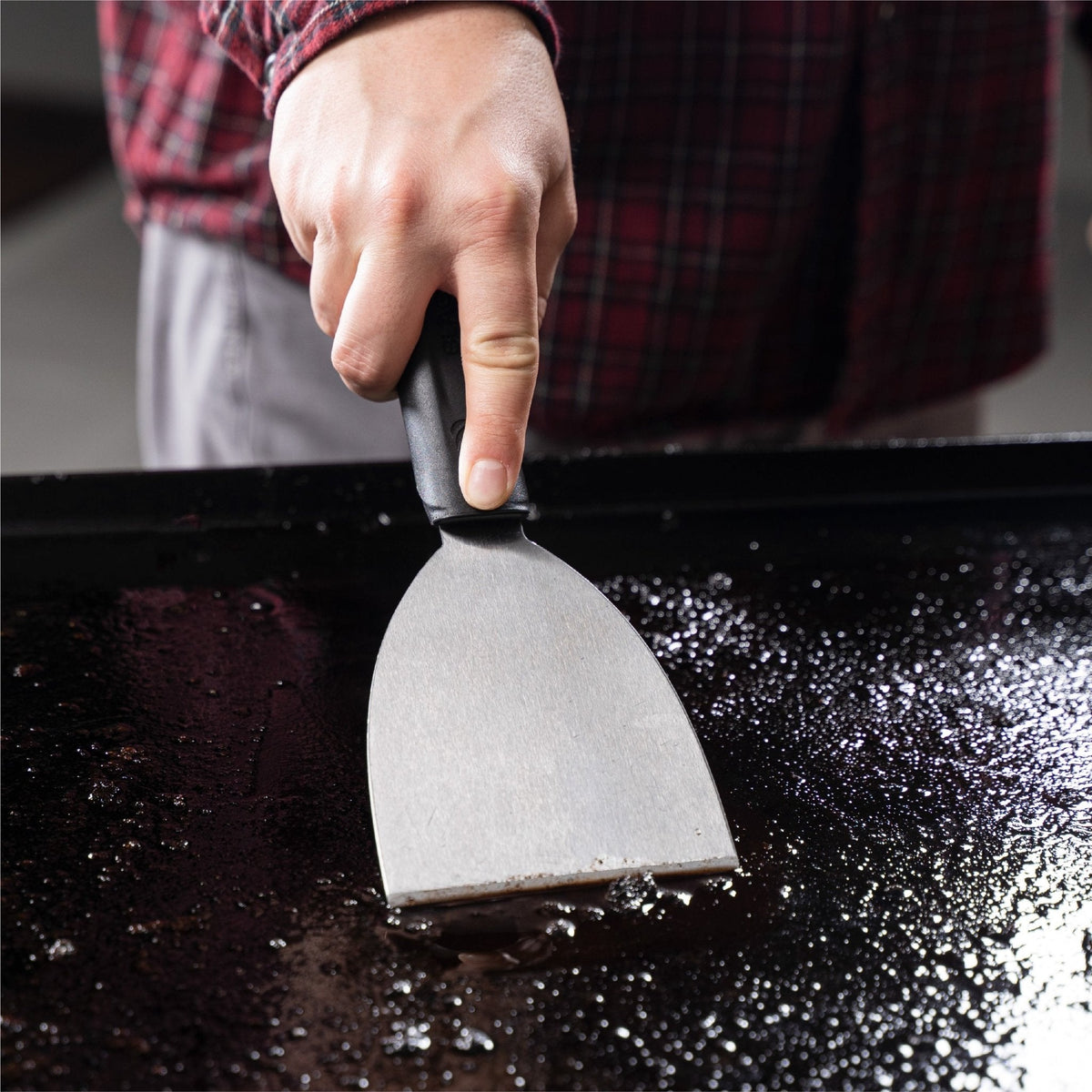 Blackstone Cleaning Kit — scraper cleaning the surface