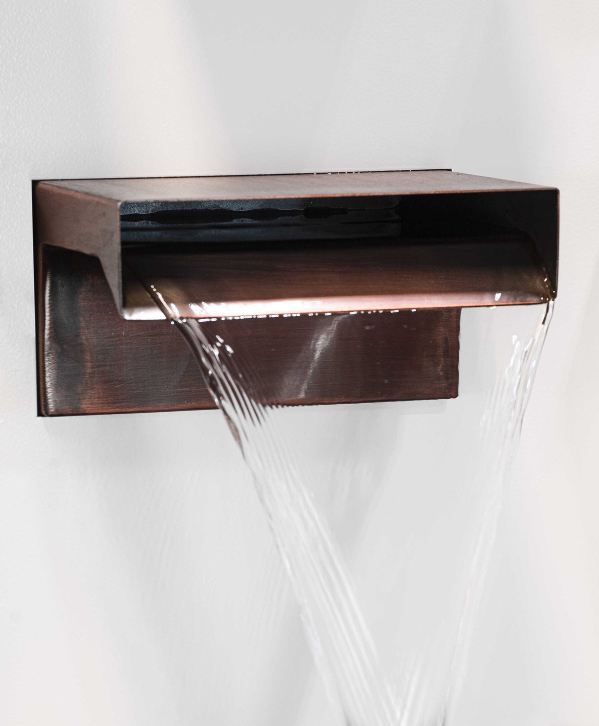 The Outdoor Plus copper Smooth Flow Scupper installed with a cascading water sheet