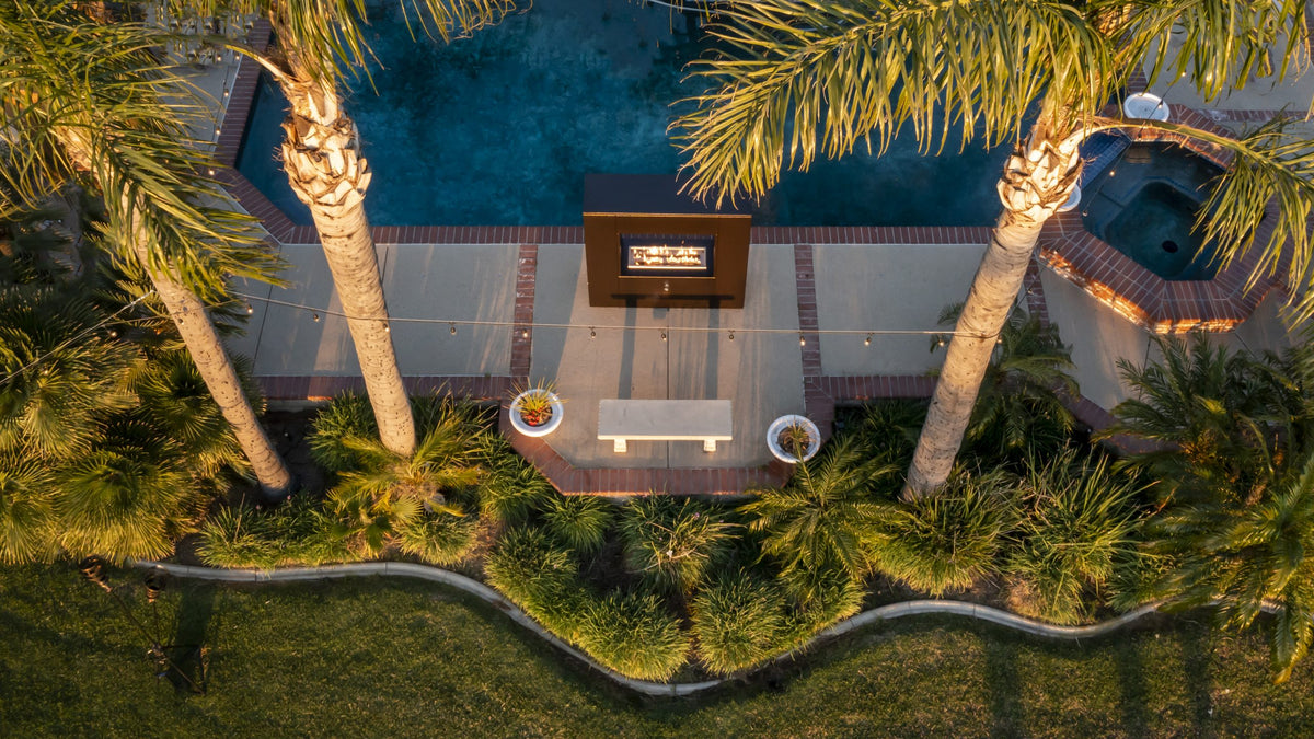 The Outdoor Plus Williams outdoor fireplace shown in Copper Vein powder coat on a patio